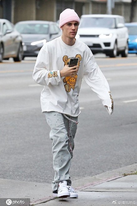 Justin Bieber3月13日在洛杉矶的街拍，他穿着白色卡通长袖TEE戴着粉色绒线帽，一身装扮俏皮可爱