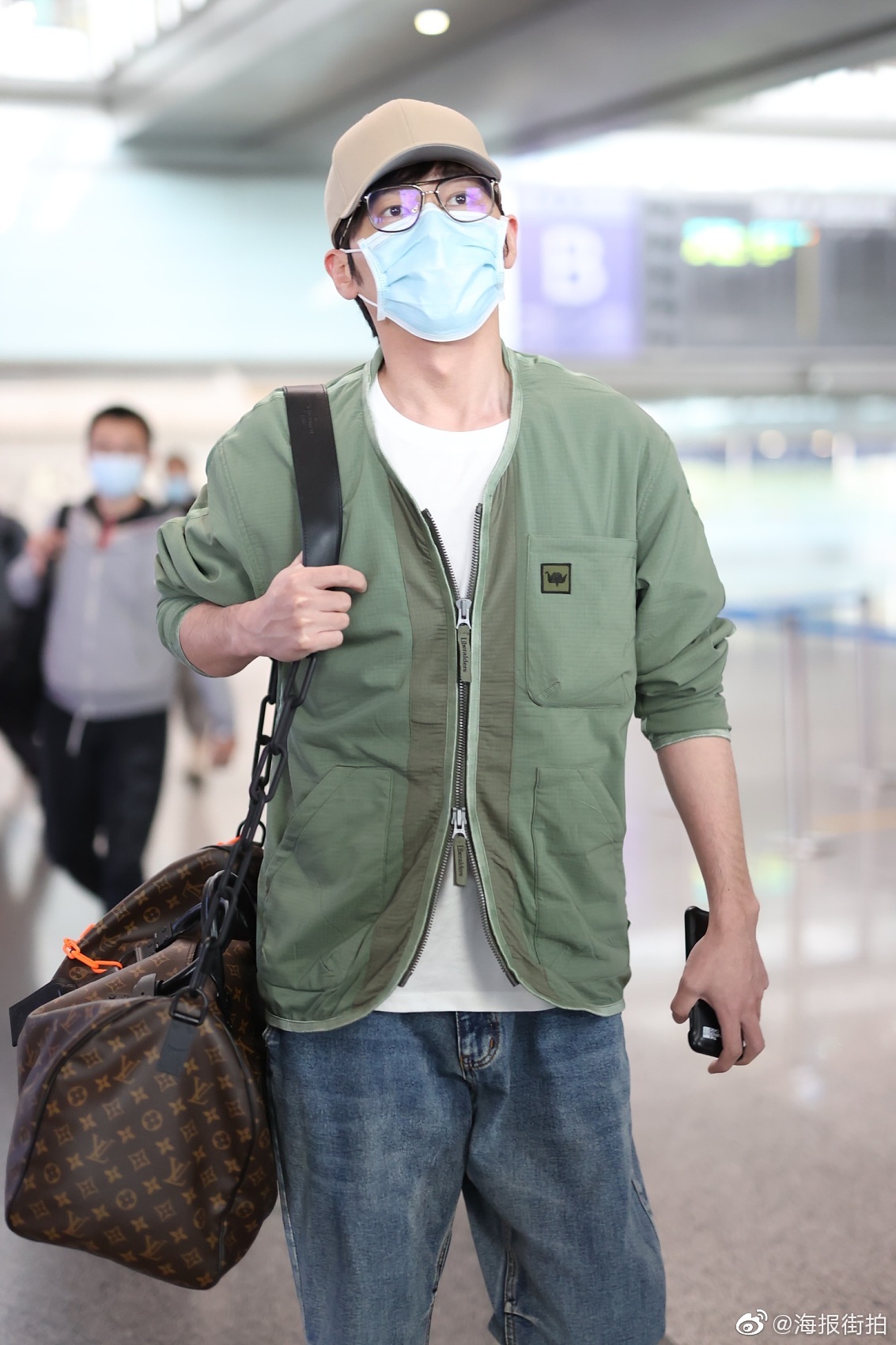 白宇 现身北京机场，一件豆沙绿棉夹克搭配Crocs洞洞鞋尽显春天气息，搭配LV挎包变身日系潮男