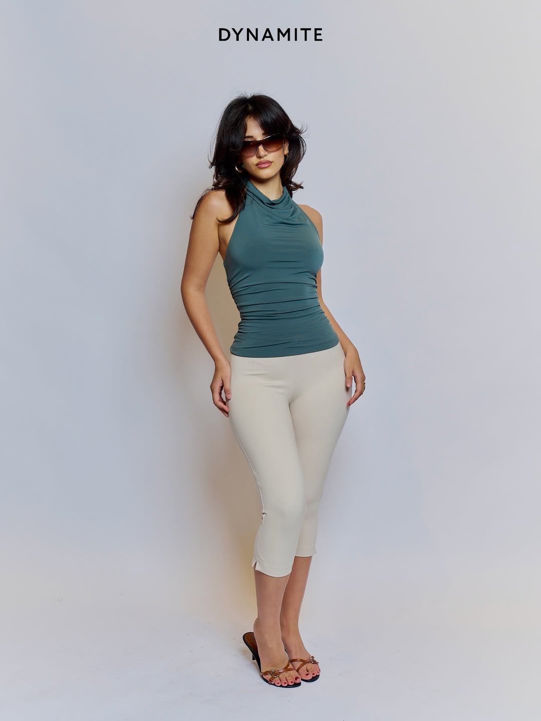 复古禧年风再现：墨绿色挂脖背心搭配米色七分裤的极简都市范儿