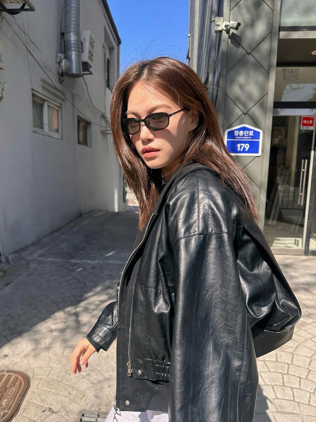 Oversize黑色皮夹克+窄框墨镜，韩式巷弄阳光下中性帅气，酷飒不羁的街头风