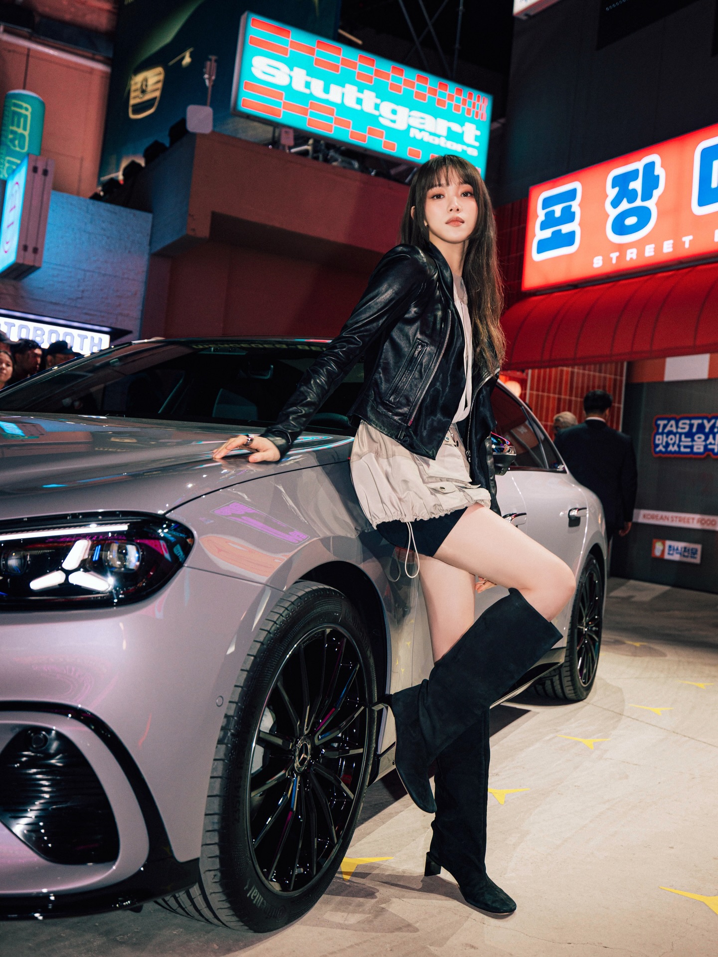 黑色皮夹克+卡其工装短裙+过膝长靴，倚靠豪车，霓虹夜景街头潮酷机车风