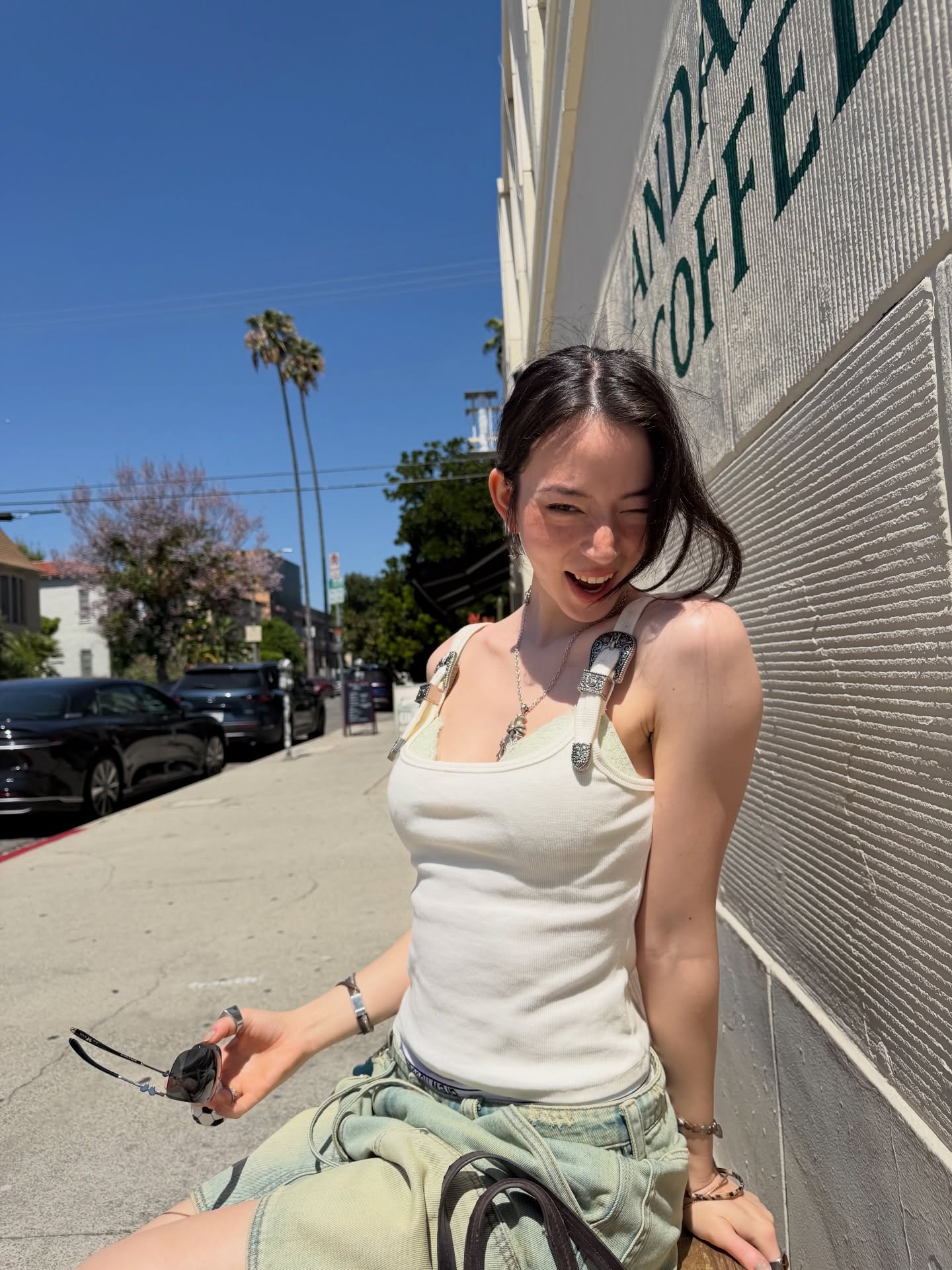 白色紧身背心+浅绿低腰牛仔短裤，叠搭腰间外套，阳光街头Y2K感俏皮随性