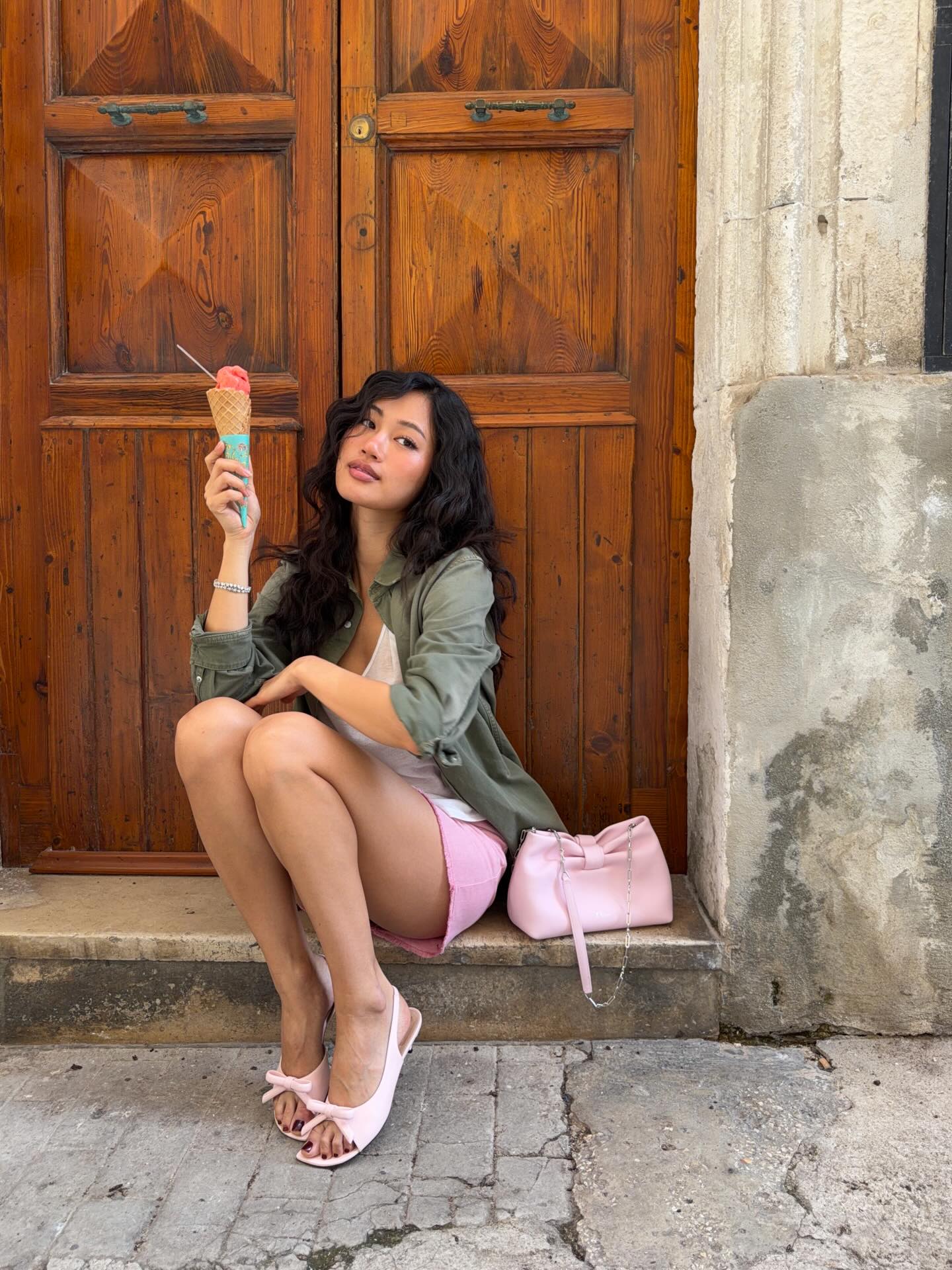 军绿色衬衫叠穿白色背心+粉色短裙，粉色蝴蝶结手袋呼应，夏日冰淇淋意式度假悠闲浪漫
