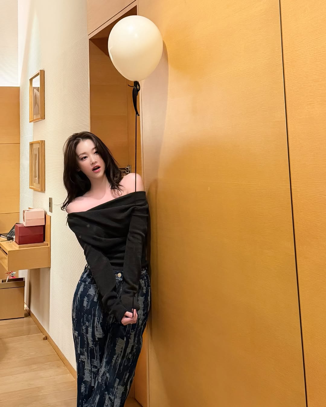 黑色一字肩上衣+扎染阔腿牛仔裤，木质墙面暖黄灯私密氛围