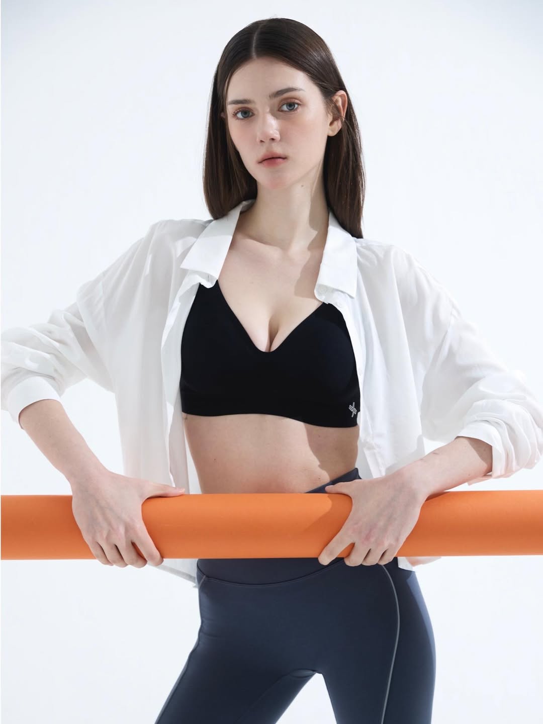 黑色运动内衣外搭宽松白衬衫，下身紧身瑜伽裤，内紧外松黑白运动极简