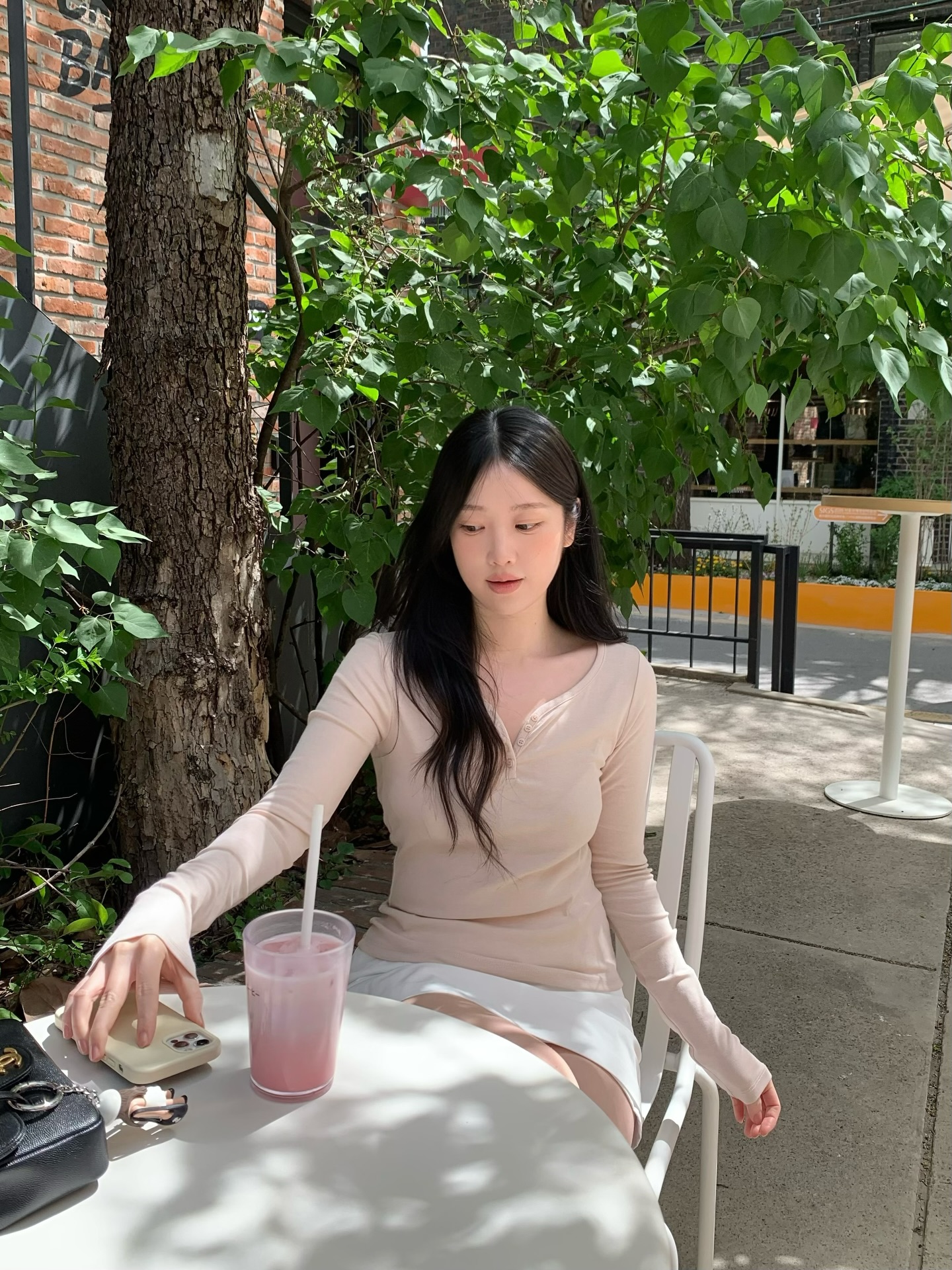 裸粉色亨利领长袖+白色长裤，柔和低饱和咖啡馆树荫恬静治愈氛围