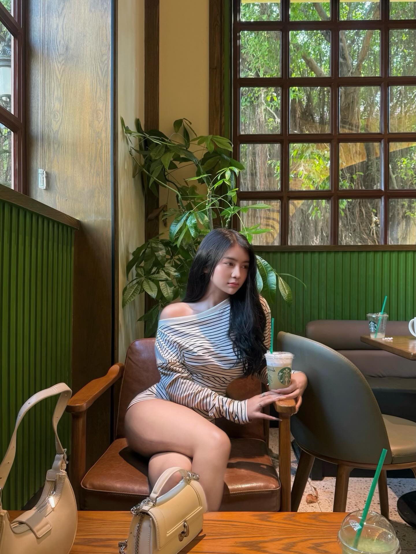 斜肩条纹紧身裙露肩设计，暖调咖啡馆绿植环绕慵懒约会感