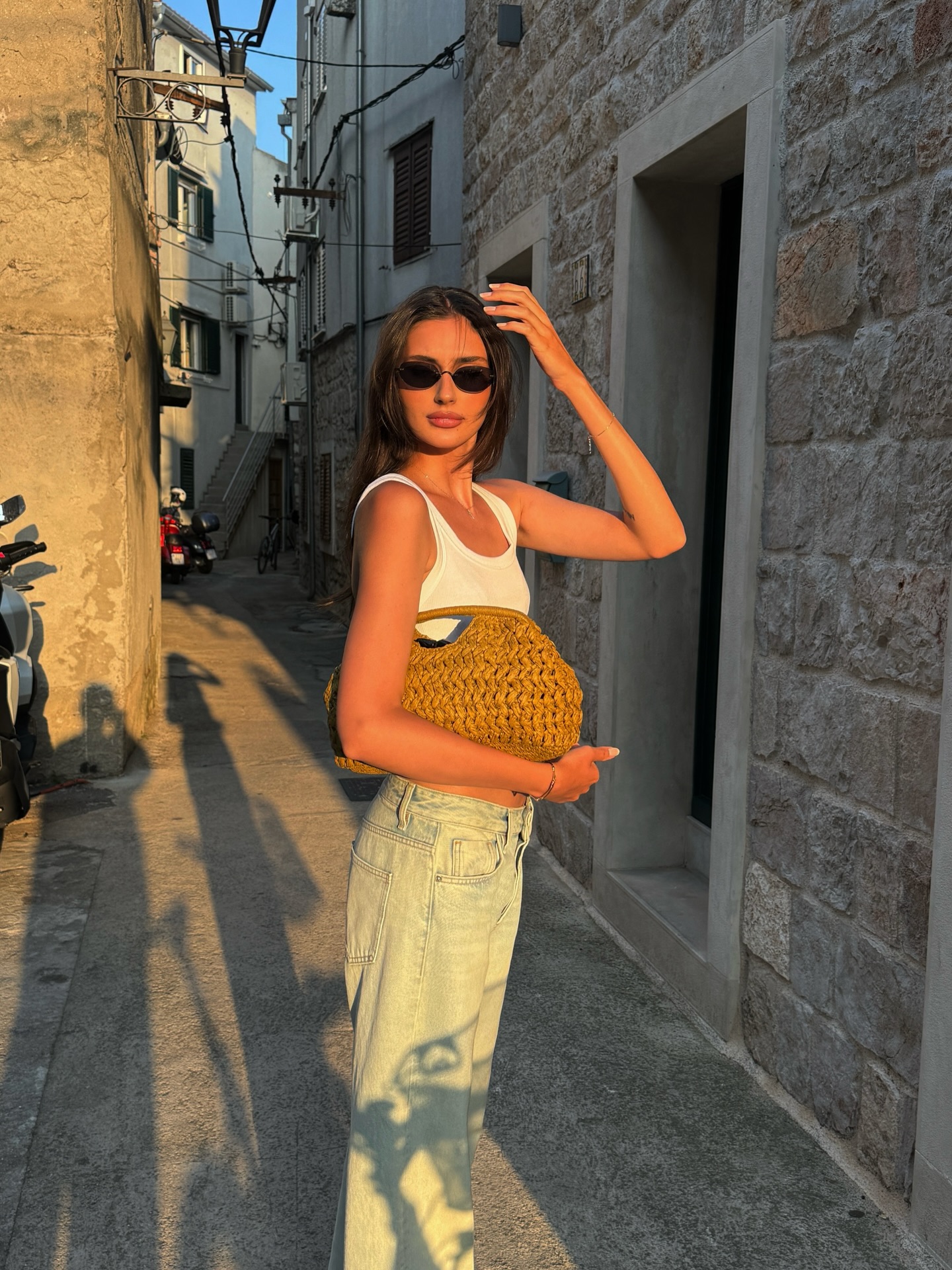 白背心+阔腿浅色牛仔，草编包猫眼墨镜落日余晖石巷南法松弛度假感