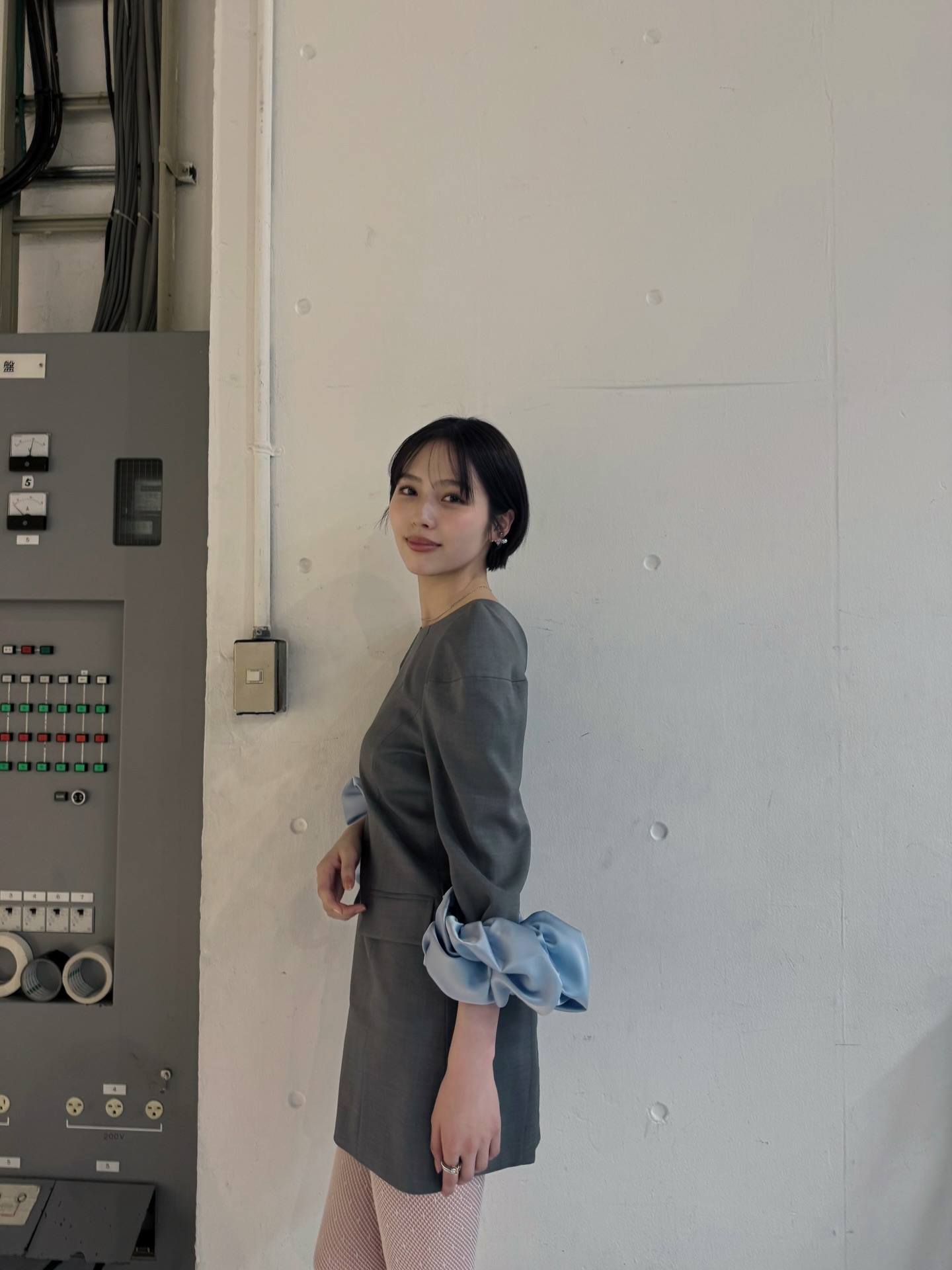 深灰色廓形连衣裙水蓝色丝绸褶皱袖口，前卫冷淡都市艺术感工业背景