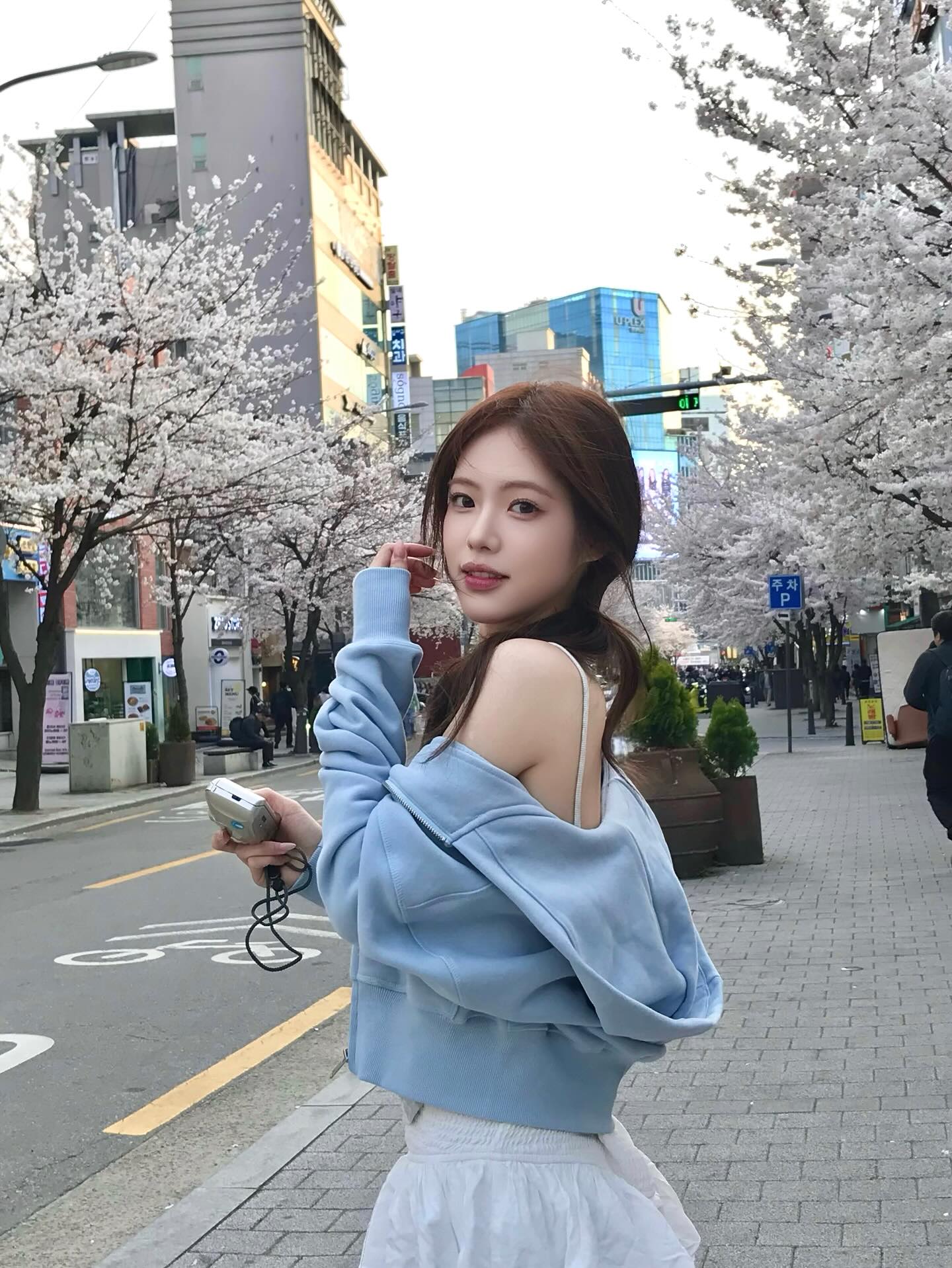 春日樱花街头的韩系清新穿搭：雾霾蓝卫衣叠穿吊带，温柔少女感满分