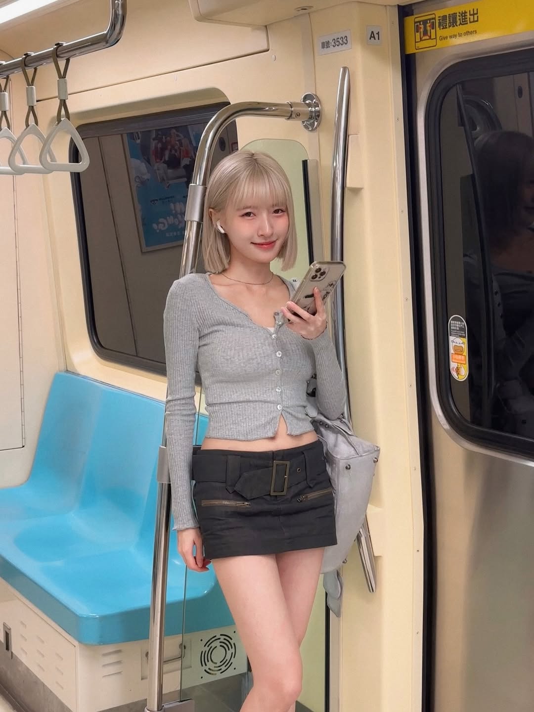 地铁上的辣妹穿搭：灰色针织开衫配黑色工装短裙