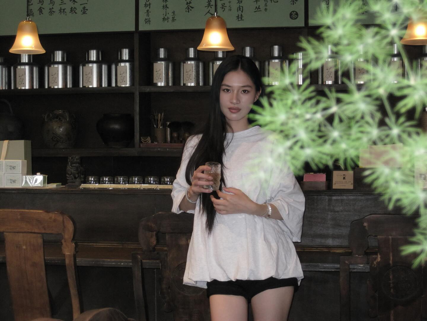 白色宽松棉麻上衣配黑色热裤，茶馆里的新中式极简美学