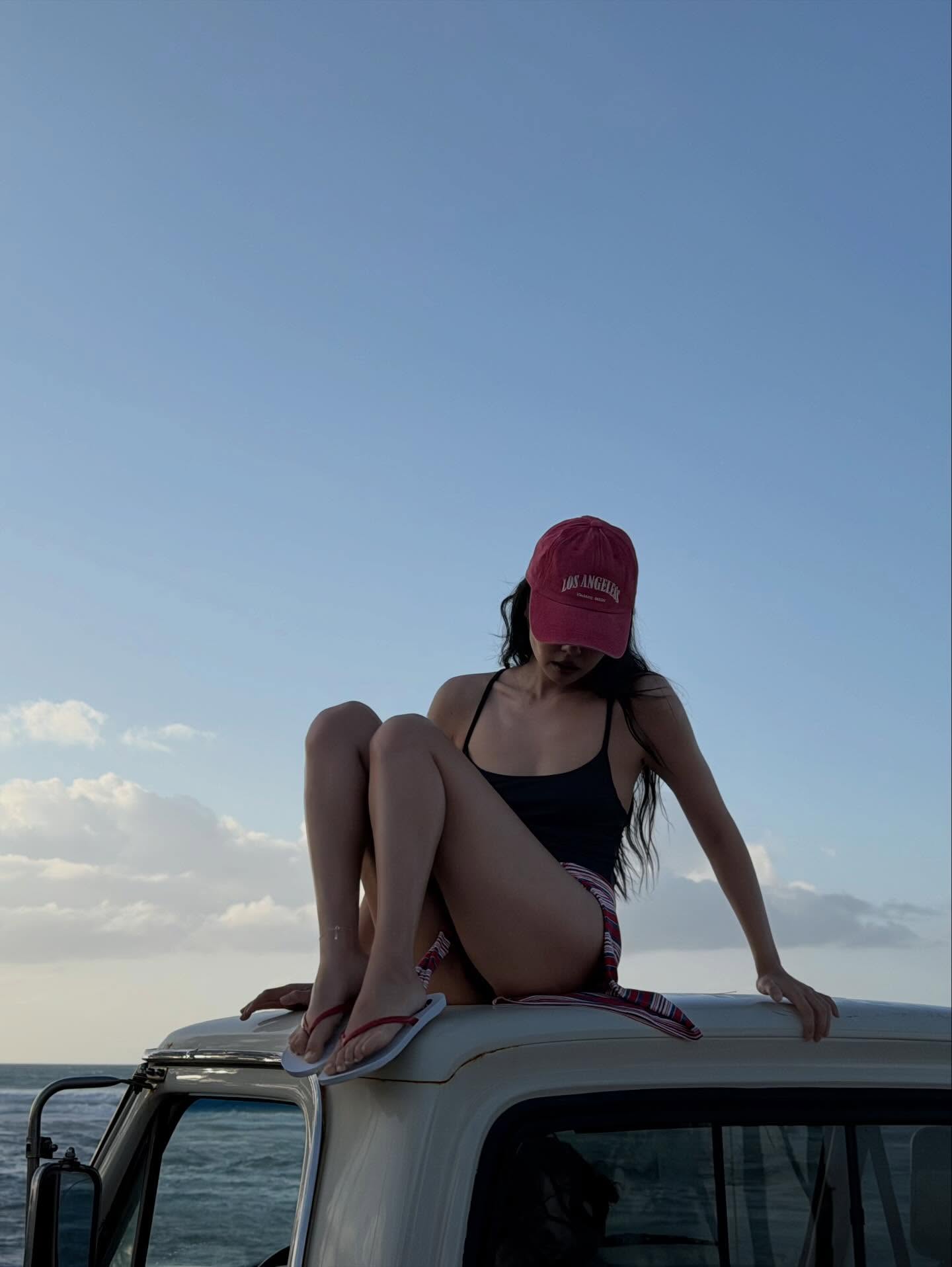 Jennie黑色露背连体泳衣配LA棒球帽，加州海滩复古面包车度假风
