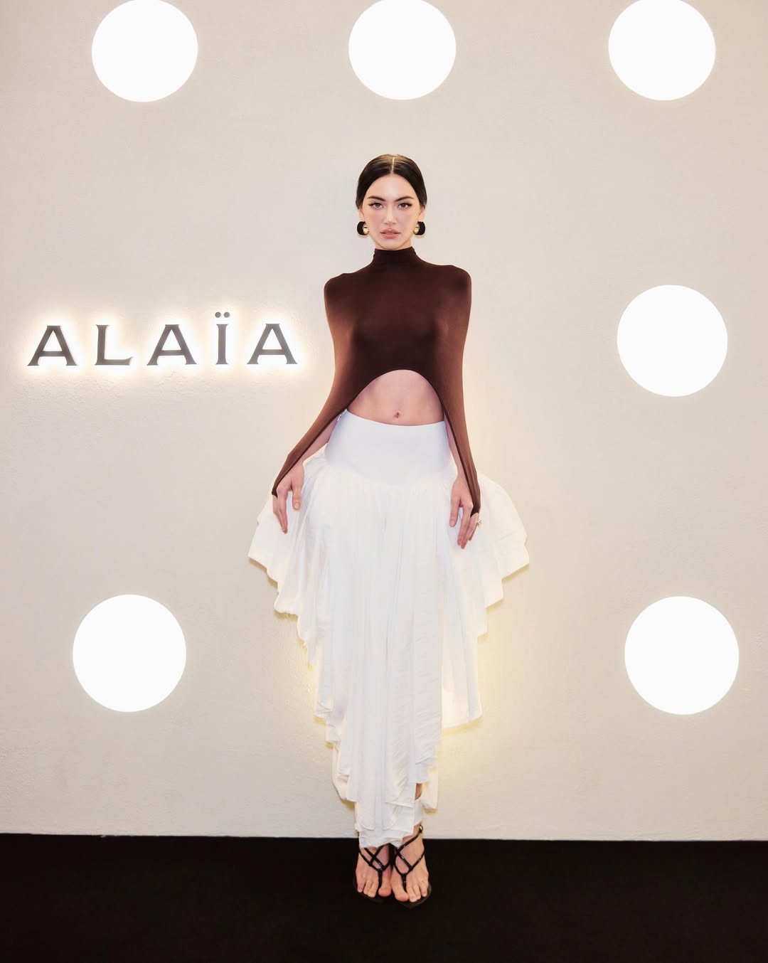 Davika Hoorne巧克力棕镂空针织衫配白色荷叶边长裙ALAÏA高定风