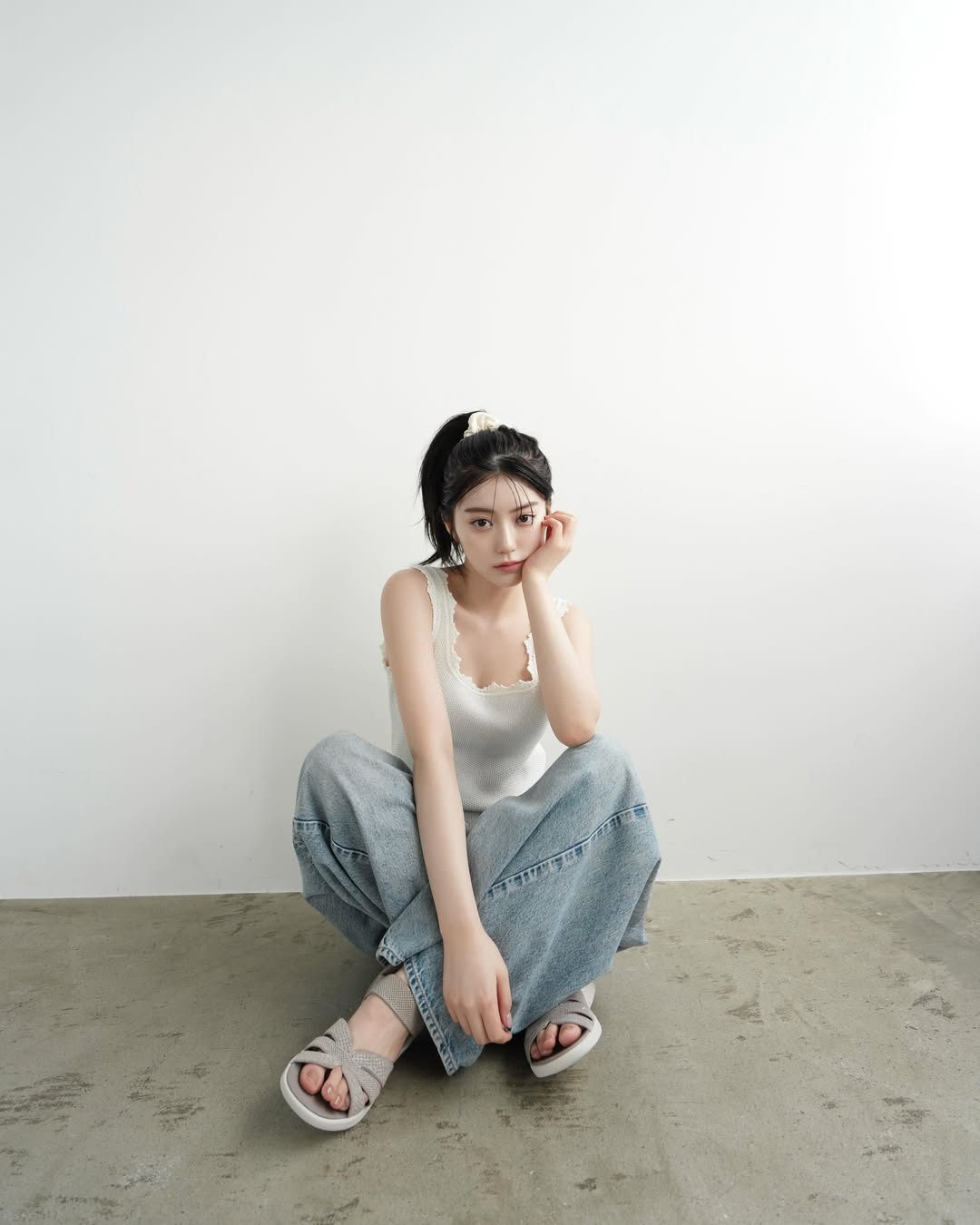 永野芽郁白色蕾丝边背心配阔腿牛仔裤，高马尾盘腿托腮