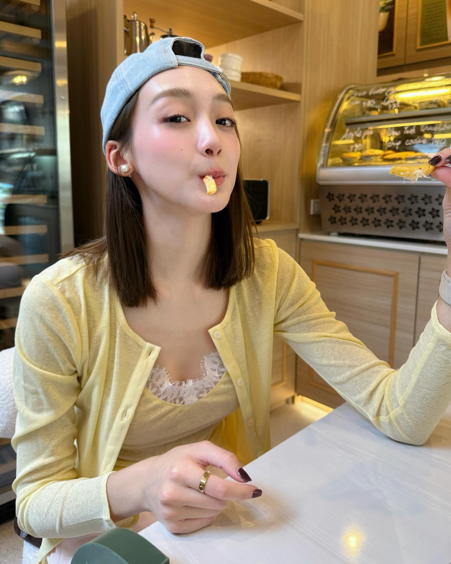 鹅黄针织开衫叠穿米色蕾丝吊带配浅蓝棒球帽，韩系温柔风