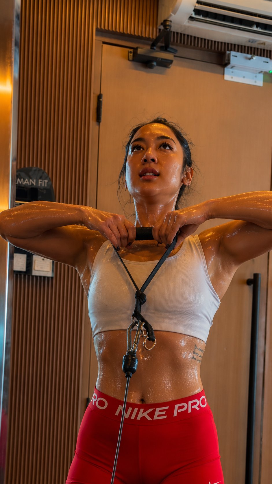 小麦色健身女生白色运动内衣配红色NikePro紧身裤